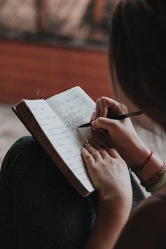 A woman writes in a diary.