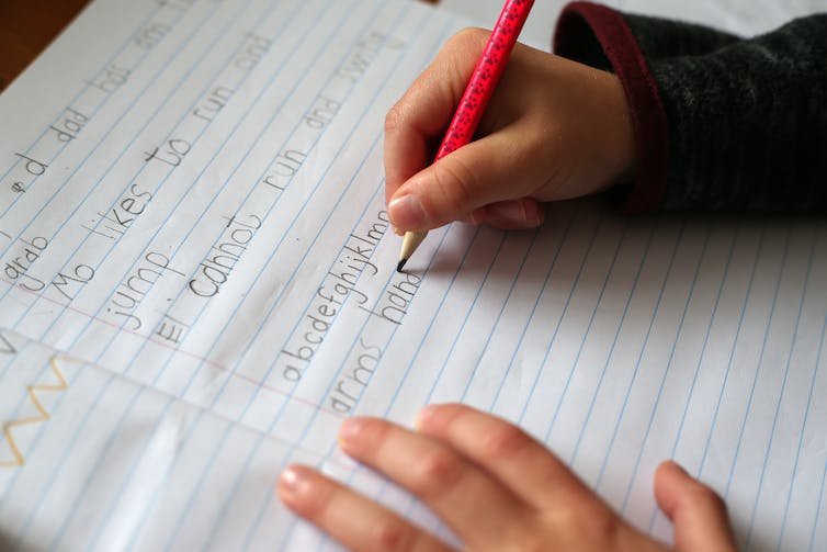 A child writes in a notebook.